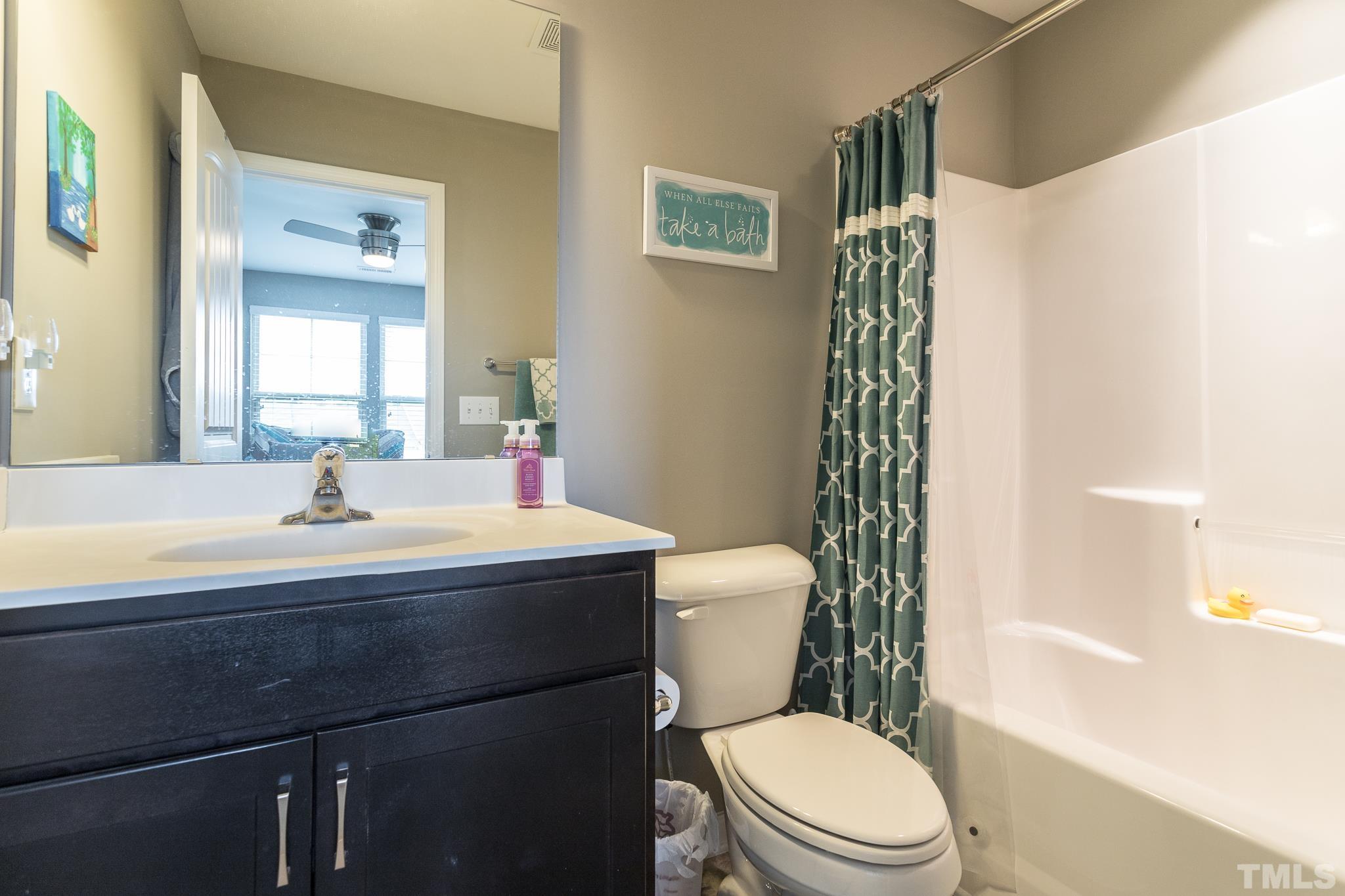 218 Irving Way Durham, NC 27703 - Photo 22 of 41 a bathroom with a sink a toilet and shower curtain