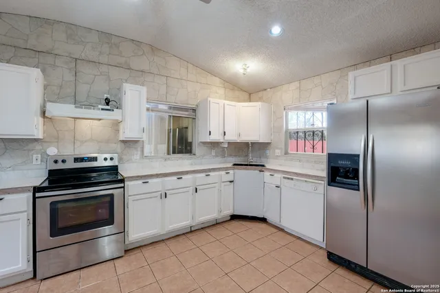 a kitchen with granite countertop cabinets stainless steel appliances and a counter space