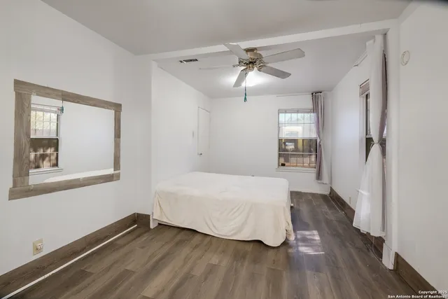 a bedroom with a bed and wooden floor