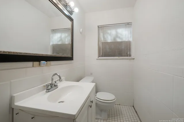 a bathroom with a sink toilet and mirror