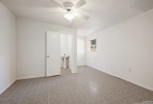an empty room with a ceiling fan and a fan