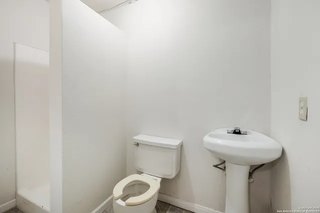 a white toilet sitting next to a white sink