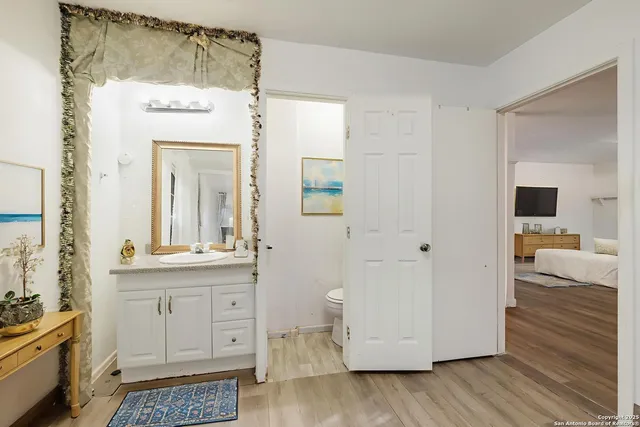 a en suite bathroom with a granite countertop sink and a mirror