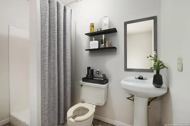 a bathroom with a sink toilet and mirror
