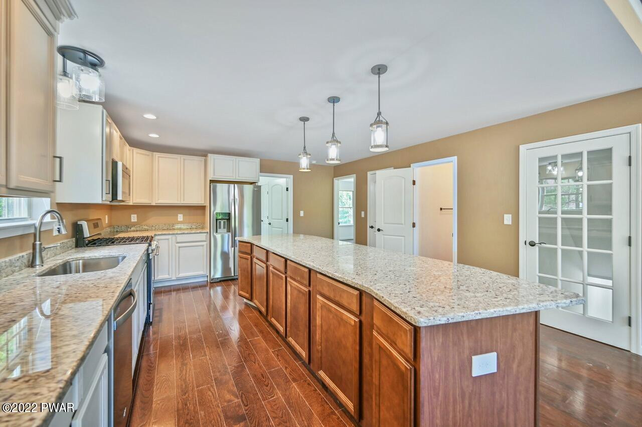 45 Rockway Road Lake Ariel, PA 18436 - Photo 29 of 65 a large kitchen with granite countertop a large center island a sink dishwasher and a stove with wooden floor