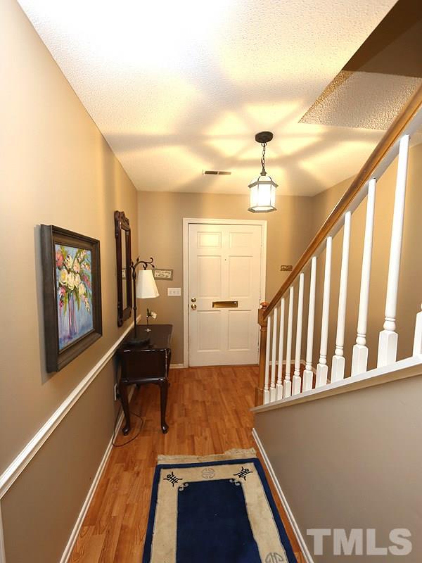 3163 Morningside Drive Raleigh, NC 27607 - Photo 2 of 18 a view of a hallway with wooden floor and staircase