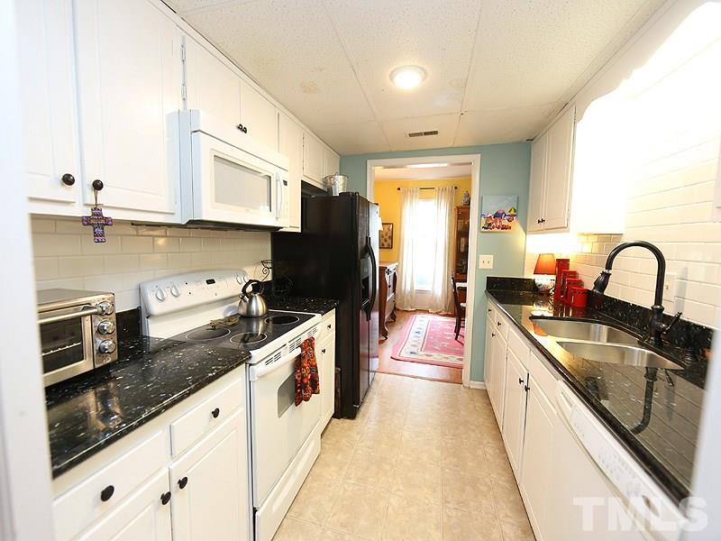3163 Morningside Drive Raleigh, NC 27607 - Photo 6 of 18 a large kitchen with granite countertop a sink and dishwasher a stove top oven with wooden floor