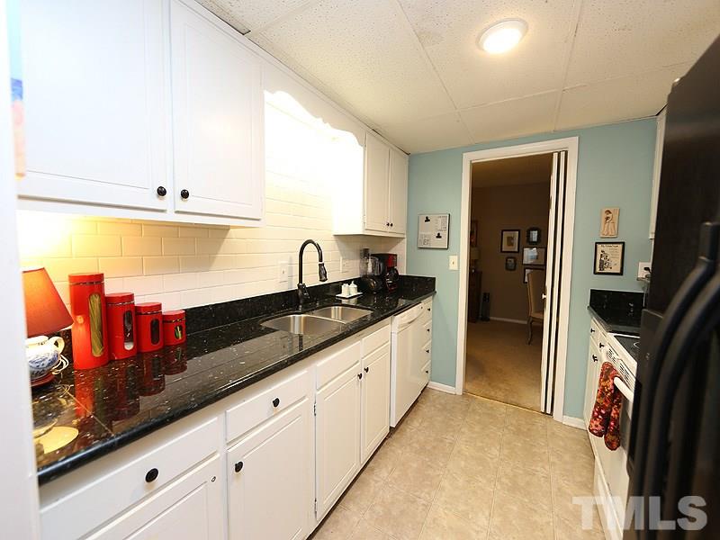 3163 Morningside Drive Raleigh, NC 27607 - Photo 7 of 18 a kitchen with stainless steel appliances granite countertop a sink and a refrigerator