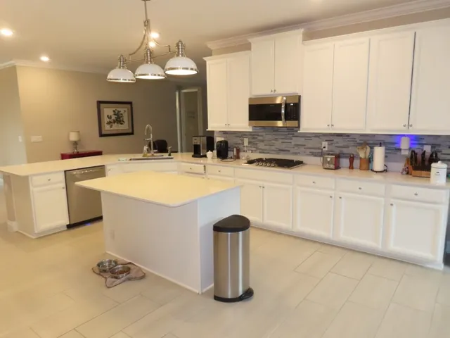 a kitchen with stainless steel appliances granite countertop a sink a stove and a microwave
