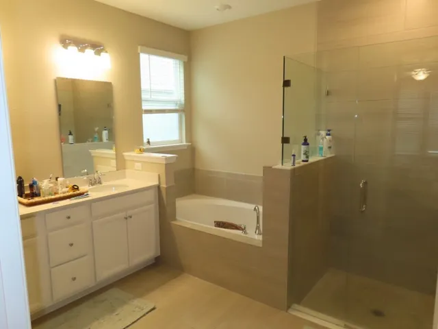 a bathroom with a double vanity sink toilet mirror and bathtub