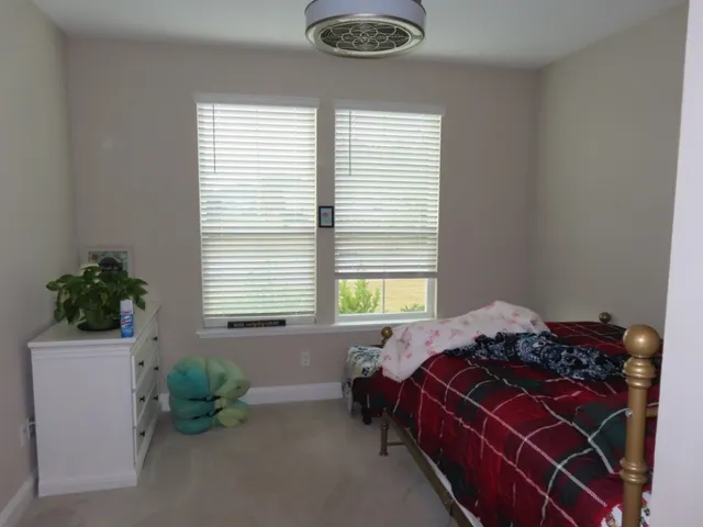 a bed sitting in a bedroom next to a window