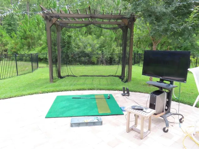 a view of backyard with seating space and trees in the background