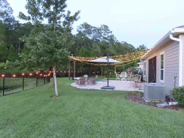 a view of a house with backyard and sitting area