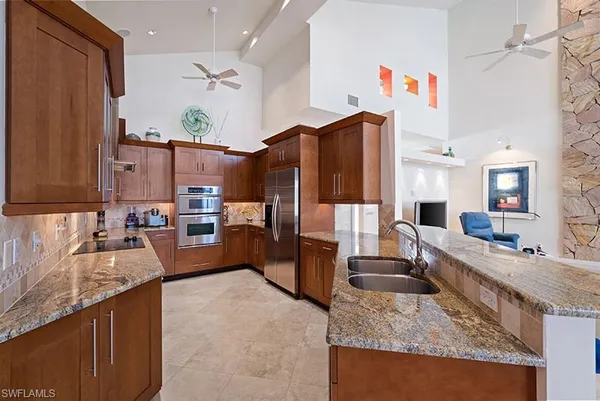a kitchen with granite countertop a sink stove and refrigerator