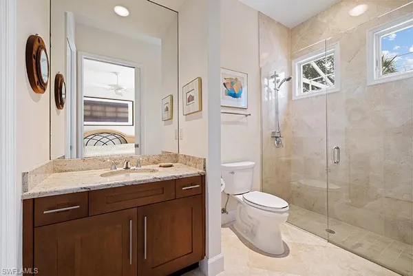 a bathroom with a granite countertop sink toilet and shower