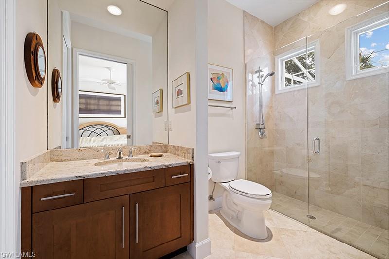 433 Crestwood Road Naples, FL 34113 - Photo 26 of 50 a bathroom with a granite countertop sink toilet and shower