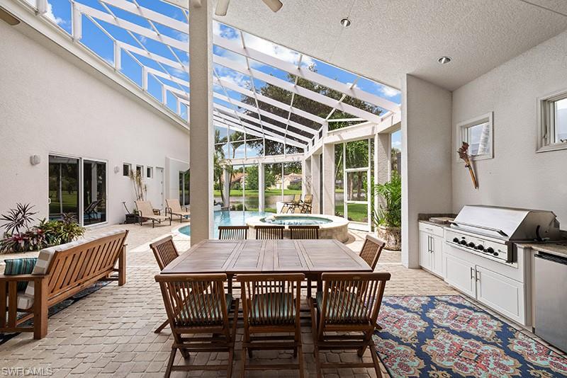433 Crestwood Road Naples, FL 34113 - Photo 3 of 50 a dining room with furniture large windows and wooden floor