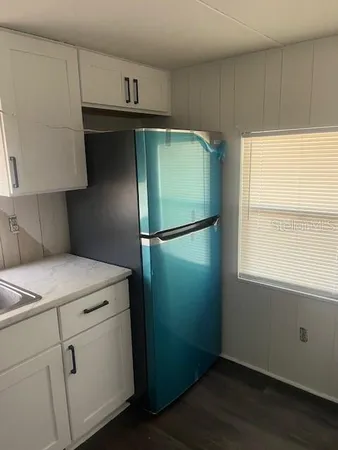 a kitchen with white cabinets and appliances
