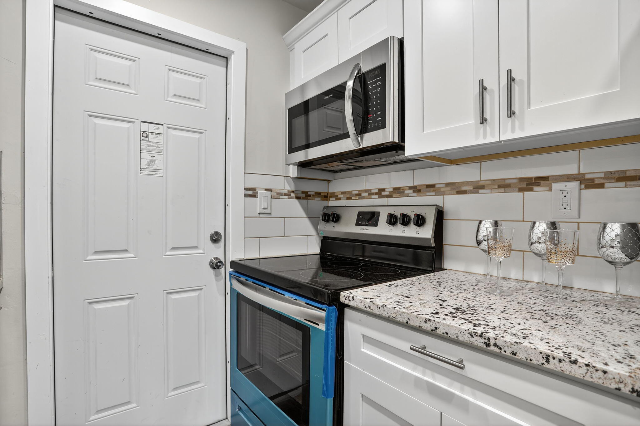 3201 Northeast 14th Street Causeway, Unit 501 Pompano Beach, FL 33062 - Photo 21 of 32 a kitchen with granite countertop white cabinets and stainless steel appliances