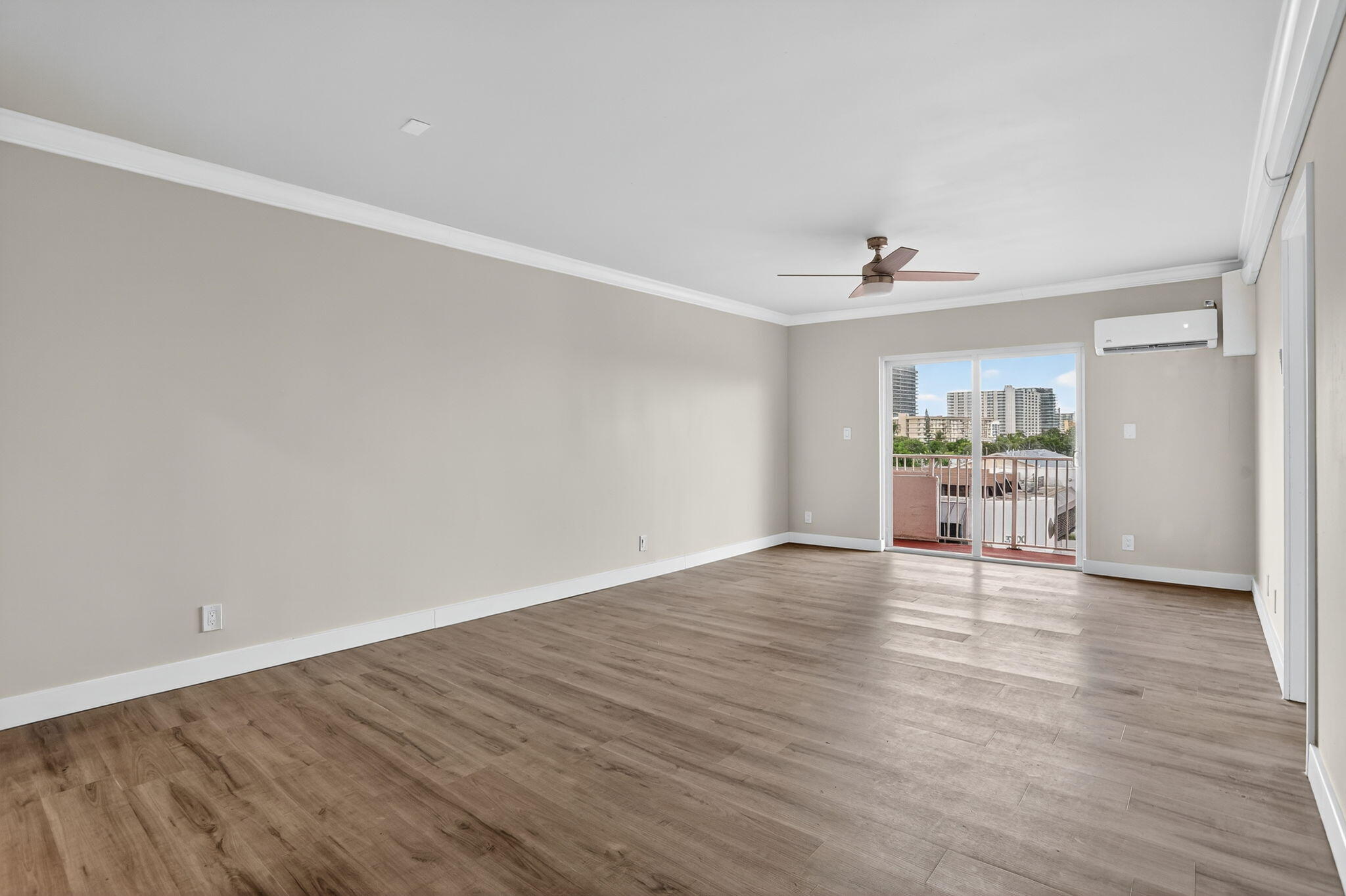 3201 Northeast 14th Street Causeway, Unit 501 Pompano Beach, FL 33062 - Photo 24 of 32 a view of an empty room with wooden floor and a window