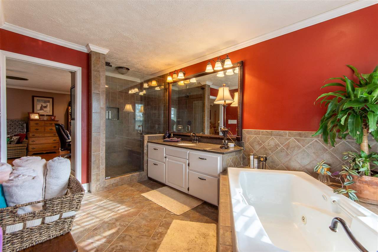 4560 Clifton Road Savannah, TN 38372 - Photo 9 of 25 a bathroom with a tub a sink and a large mirror