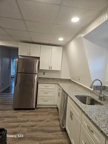 a kitchen with a sink a refrigerator and cabinets