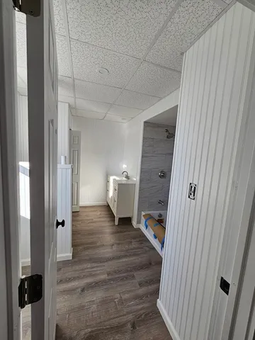a view of a hallway with wooden floor and staircase