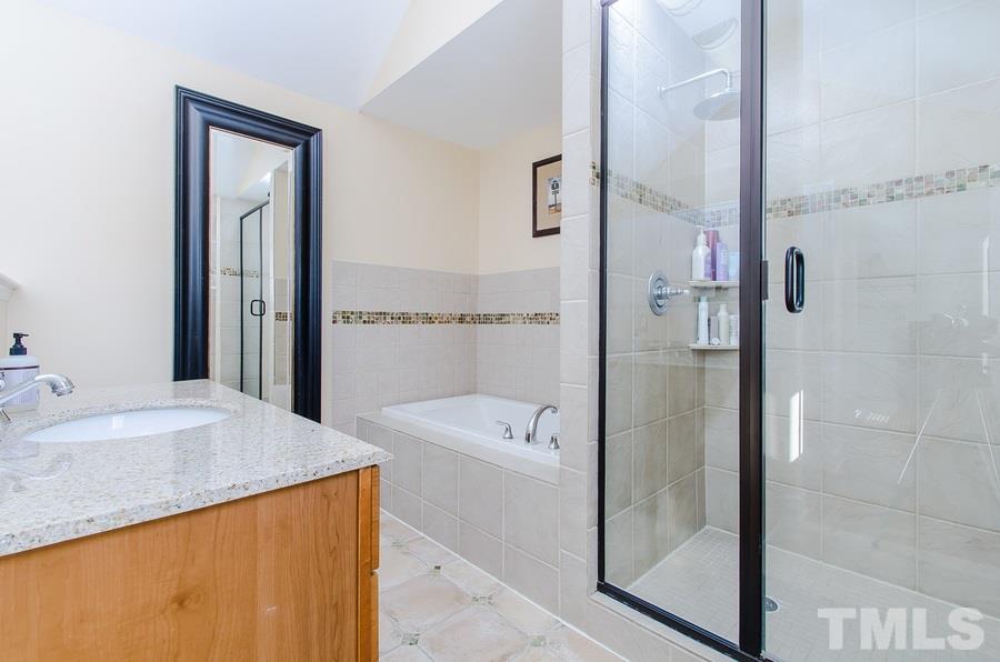 1705 Midwood Drive Raleigh, NC 27604 - Photo 13 of 24 a en suite bathroom with a granite countertop sink a mirror and shower