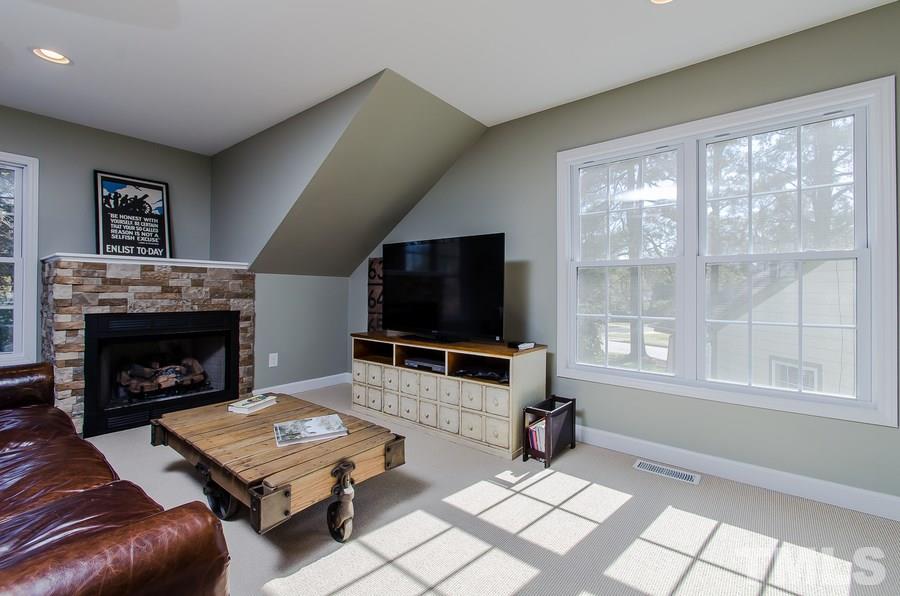 1705 Midwood Drive Raleigh, NC 27604 - Photo 18 of 24 a living room with furniture a flat screen tv and a fireplace
