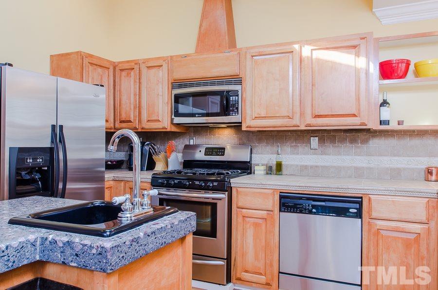 1705 Midwood Drive Raleigh, NC 27604 - Photo 24 of 24 a kitchen with stainless steel appliances granite countertop a stove a sink and a microwave