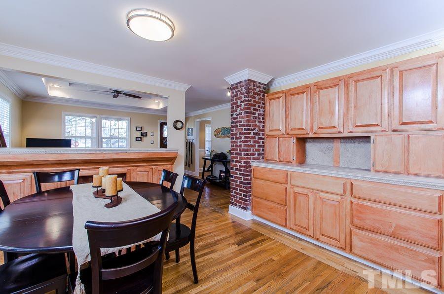 1705 Midwood Drive Raleigh, NC 27604 - Photo 8 of 24 a kitchen with a dining table chairs and cabinets