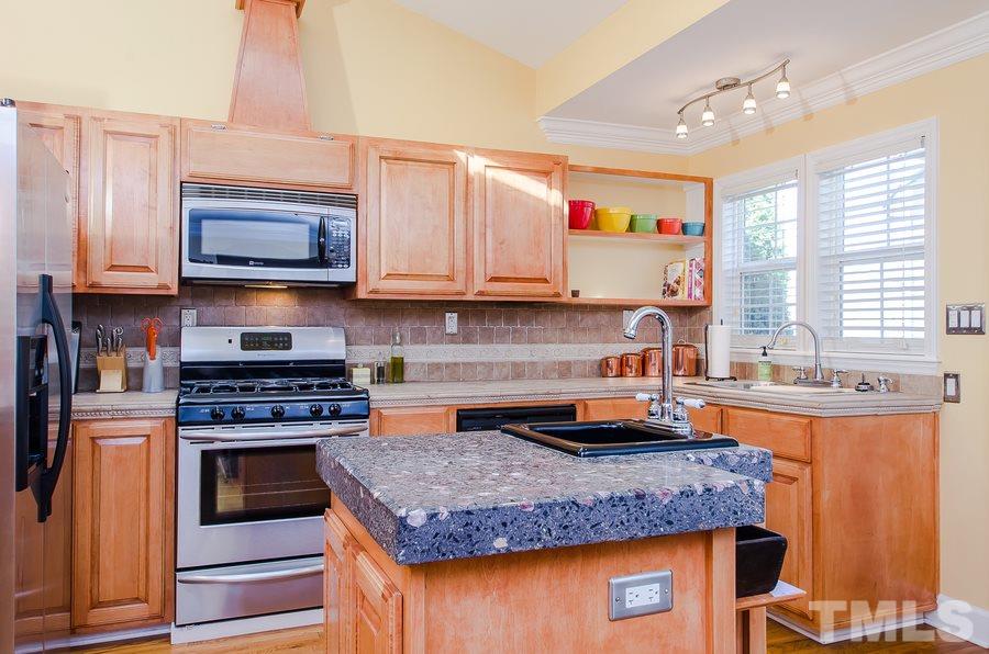 1705 Midwood Drive Raleigh, NC 27604 - Photo 9 of 24 a kitchen with granite countertop stainless steel appliances a stove sink and microwave