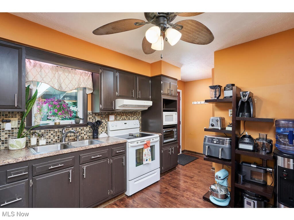 2643 Massillon Road Akron, OH 44312 - Photo 6 of 33 Kitchen with white appliances, ceiling fan, dark hardwood / wood-style floors, and tasteful backsplash