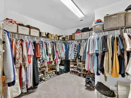 a view of walk in closet with clothes