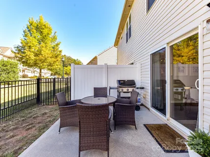 a patio with glass top table and chairs