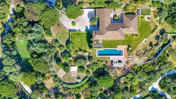 an aerial view of a house with a garden and trees