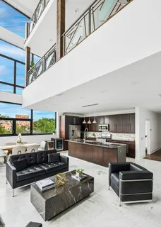 a living room with stainless steel appliances granite countertop a couch a stove and a kitchen view