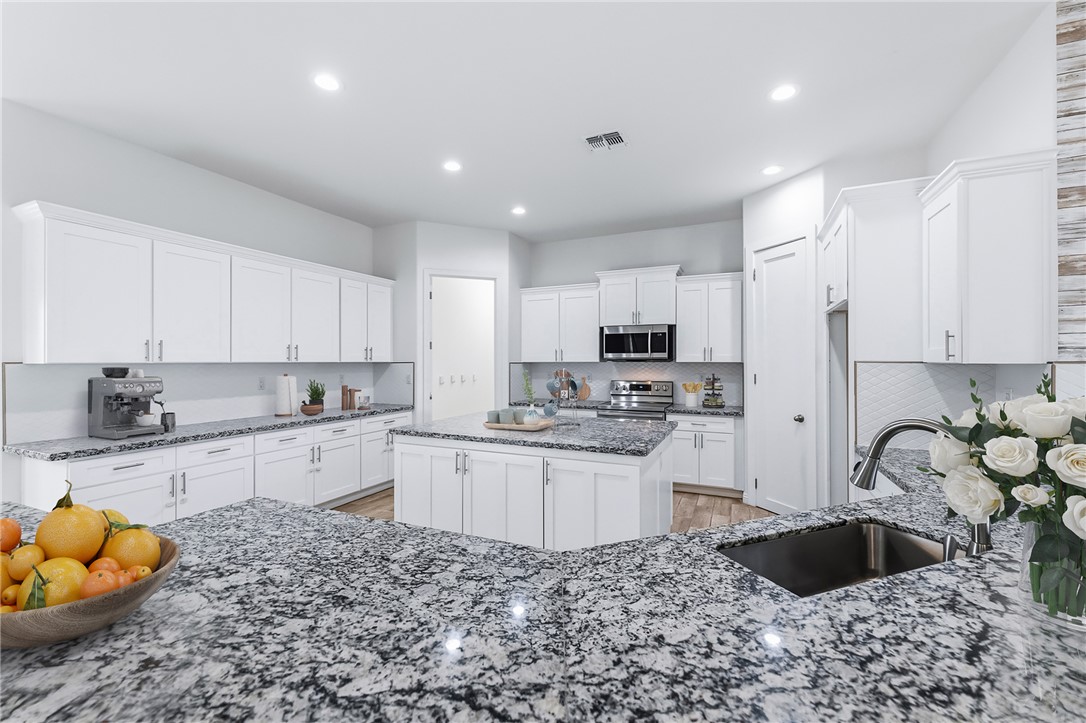 2385 Corwin Road Bullhead City, AZ 86442 - Photo 28 of 78 a kitchen with stainless steel appliances kitchen island granite countertop a sink and white cabinets