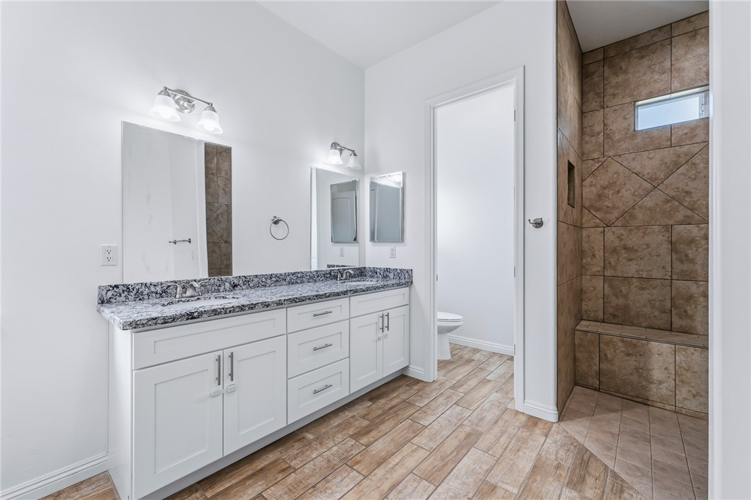 2385 Corwin Road Bullhead City, AZ 86442 - Photo 38 of 78 a spacious bathroom with a granite countertop sink a toilet a mirror and shower