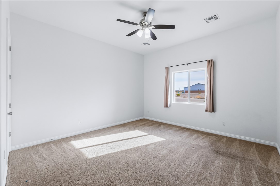 2385 Corwin Road Bullhead City, AZ 86442 - Photo 42 of 78 an empty room with a chandelier fan and windows