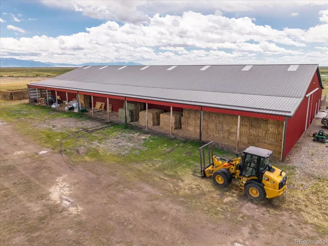 a view of a house with lawn chairs next to a yard