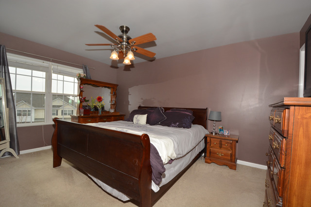 285 South Oak Creek Lane, Unit 285 Romeoville, IL 60446 - Photo 13 of 24 a bed sitting in a bedroom next to a window