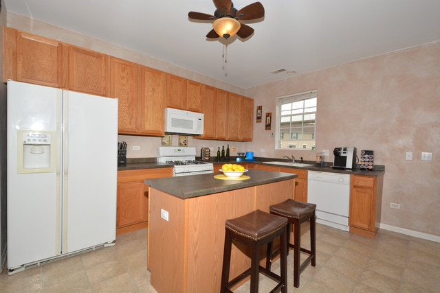 285 South Oak Creek Lane, Unit 285 Romeoville, IL 60446 - Photo 3 of 24 a kitchen with stainless steel appliances granite countertop a refrigerator a sink a stove and white cabinets