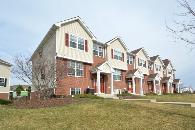285 South Oak Creek Lane, Unit 285 Romeoville, IL 60446 - Photo 21 of 24 a front view of residential houses with yard and trees