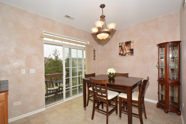 285 South Oak Creek Lane, Unit 285 Romeoville, IL 60446 - Photo 5 of 24 a view of a dining room with furniture and chandelier