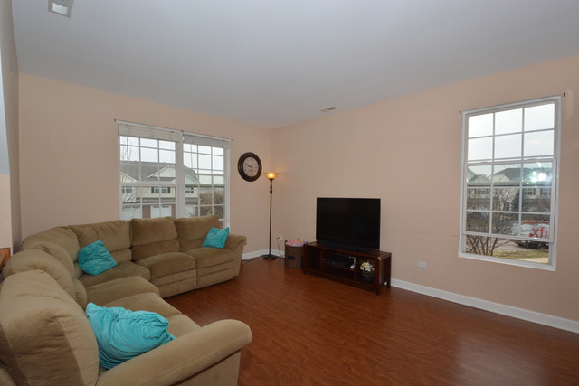 285 South Oak Creek Lane, Unit 285 Romeoville, IL 60446 - Photo 8 of 24 a living room with furniture and a flat screen tv