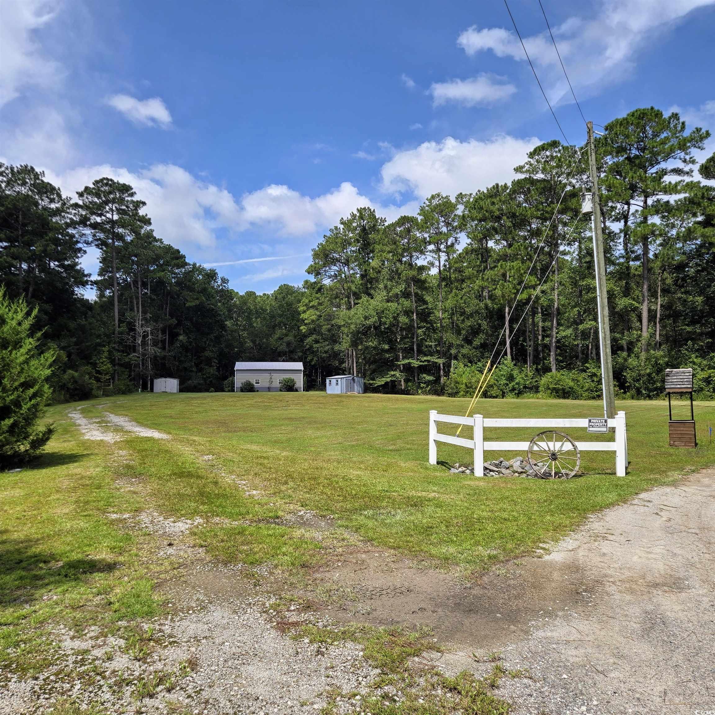 428 Bear Grass Road East Longs, SC 29568 - Photo 3 of 18 View of grassy yard featuring a wooded view and a storage unit