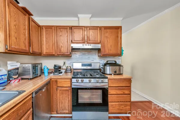a kitchen with stainless steel appliances granite countertop a stove a sink and a microwave