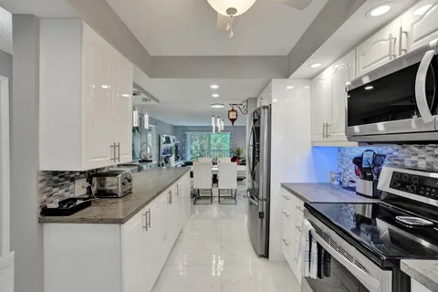 a kitchen with stainless steel appliances granite countertop a sink stove microwave and cabinets