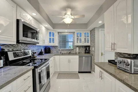 a kitchen with stainless steel appliances granite countertop a stove a sink and a refrigerator